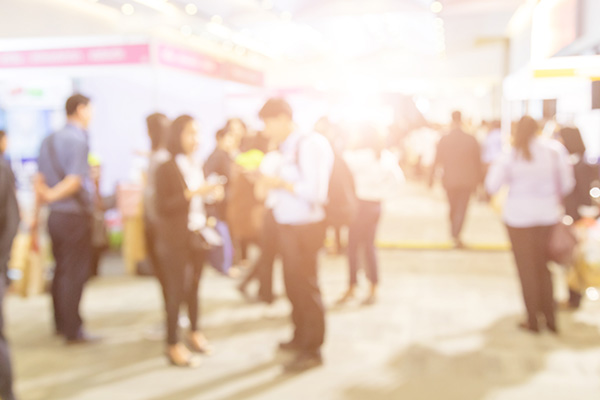 A blurred background image of people networking at a busy career fair.
